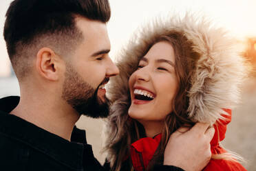 Junges attraktives Paar in Winterkleidung lachend bei einem Date - ADSF39018