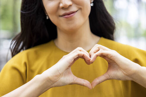 Hands of woman making heart shape - WPEF06491