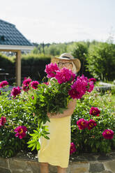 Frau hält frischen Blumenstrauß im Garten stehend - SEAF01302