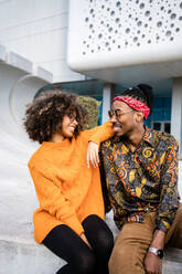 Stylish ethnic in love African American couple looking at each other while spending time in city park - ADSF39031