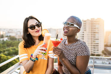 From above stylish multiethnic lesbian females drinking cold refreshing cocktails in summer - ADSF39198