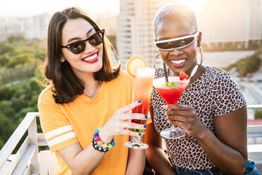 Stylish multiethnic lesbian females drinking cold refreshing cocktails in summer - ADSF39200