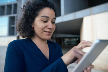 Businesswoman using tablet PC at office park - JOSEF13367