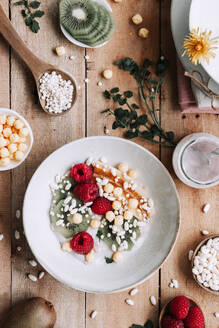 Draufsicht auf eine Schale mit frischen Früchten und Beeren auf einem rustikalen Holztisch - ADSF39257