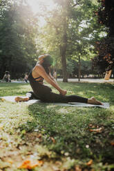 Yogalehrer übt Ardha Kapotasana im Park - MRRF02480