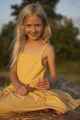 Smiling girl with blond hair on haystack - NJAF00010