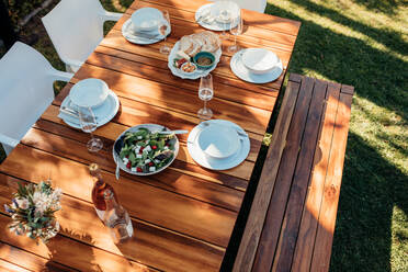 Draufsicht auf Essen auf Holztisch für Einweihungsparty. Tisch im Freien mit Essen und Trinken. - JLPSF00124