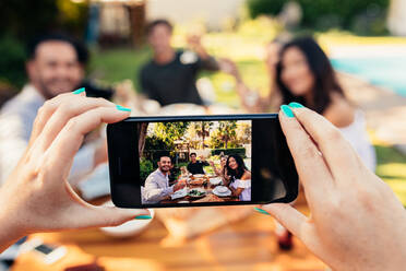 Young people having fun outdoors. Group of friends posing while their friend take a picture with his smart phone. Female hands taking picture of friends having party. - JLPSF00140