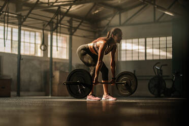 Fit jungen weiblichen Athleten heben schwere Gewichte. Fitness-Modell Durchführung Gewichtheben Übung im Fitnessstudio. - JLPSF00330