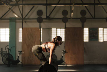 Starke junge Frau, die im Fitnessstudio schwere Gewichte stemmt, Fitness-Frau, die mit schweren Gewichten trainiert. - JLPSF00333