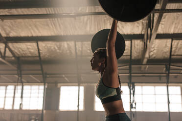 Starke und zähe Frau beim Training mit schweren Gewichten im Fitnessstudio. Frau beim Kreuzheben mit Langhantel. - JLPSF00353