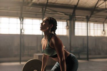 Muskulöse Sportlerin, die im Fitnessstudio Gewichte stemmt. Fitness-Frau, die im Fitnessstudio Gewichte stemmt. - JLPSF00356