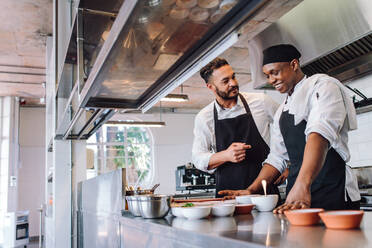 Glückliche Männer Köche kochen Essen im Café Küche. Zwei Köche machen Essen Gerichte im Restaurant Küche. - JLPSF00417