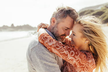 Liebevolles älteres Paar, das sich am Strand umarmt. Älterer Mann und Frau, die sich im Freien umarmen. - JLPSF00488