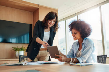 Aufnahme von Geschäftsleuten bei einer Besprechung im Büro, die ein digitales Tablet verwenden. Geschäftspartner verwenden einen Touchscreen-Computer für eine Projektbesprechung. - JLPSF00556