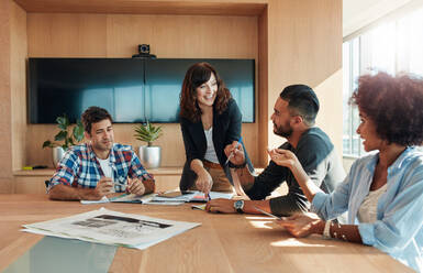 Aufnahme einer Gruppe junger Geschäftsleute, die sich in einem Sitzungssaal treffen. Büroangestellte, die in einem Konferenzraum gemeinsam einen neuen Geschäftsplan besprechen. - JLPSF00566