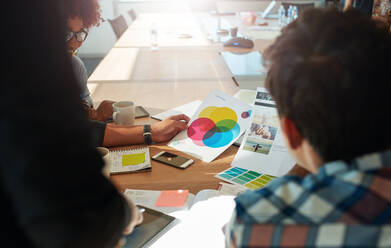Team-Brainstorming im Besprechungsraum mit Farbmustern. Eine Gruppe von Personen sitzt am Tisch mit einer Farbpalette auf dem Tisch. - JLPSF00575