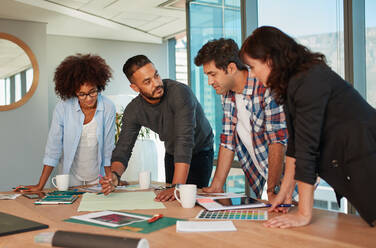 Shot of a group of young creative professionals having a meeting in boardroom. Office workers discussing new project together in office. - JLPSF00581