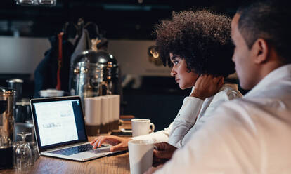 Geschäftsleute arbeiten spät an einem Laptop. Geschäftspartner verwenden Laptop-Computer in einem Startup-Büro. - JLPSF00643