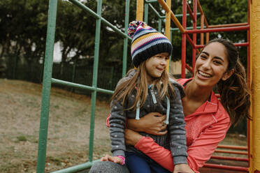 Woman spending time with a girl at the playground. Babysitter playing with a girl at the park. - JLPSF00732