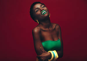 Schöne afrikanische Frau mit lebendigen Make-up. Schönheit Porträt der sinnlichen Modell mit bunten Make-up auf rotem Hintergrund. - JLPSF00773