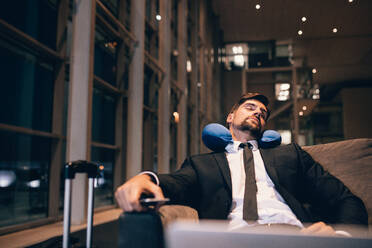 Reisende warten am Flughafen nach Verspätungen und Annullierungen von Flügen. Geschäftsmann schläft in der Flughafen-Lounge. - JLPSF00907