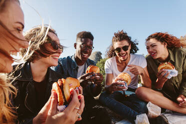 Junge Leute beim Sommerpicknick und beim gemeinsamen Essen auf einem Berggipfel. Glückliche Freunde auf einem Berggipfel beim Picknick an einem Sommertag. - JLPSF00973