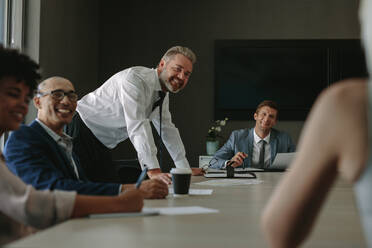 Group of corporate professionals at meeting discussing new strategy of their business. Business people having meeting in conference room. - JLPSF01049