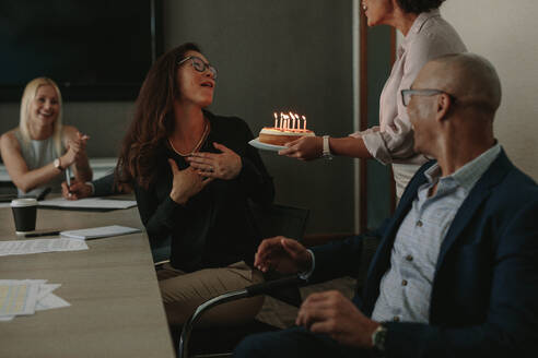 Büroangestellte feiern den Geburtstag einer weiblichen Führungskraft mit einem Kuchen im Konferenzraum. Arbeiter feiern den Geburtstag eines Kollegen im Büro. - JLPSF01055