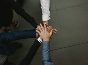 Top view of business people putting their hands together. Stack of hands. Unity and teamwork concept. - JLPSF01069