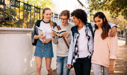 Gruppe von Universitätsstudenten mit Büchern auf dem College-Campus. Studenten diskutieren auf der Straße. - JLPSF01212