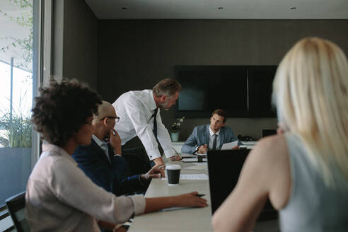 Eine Gruppe von Mitarbeitern bei einer Besprechung in einem Büro. Fachleute aus der Wirtschaft diskutieren bei einer Besprechung im Konferenzraum. - JLPSF01353