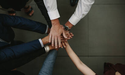 Unity and teamwork Concept. Top view of business people putting their hand together. - JLPSF01379