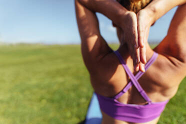 Entschlossene Frau praktiziert Yoga im Freien. Fitness Frau mit Händen hinter dem Kopf verbunden tun Meditation. - JLPSF01407