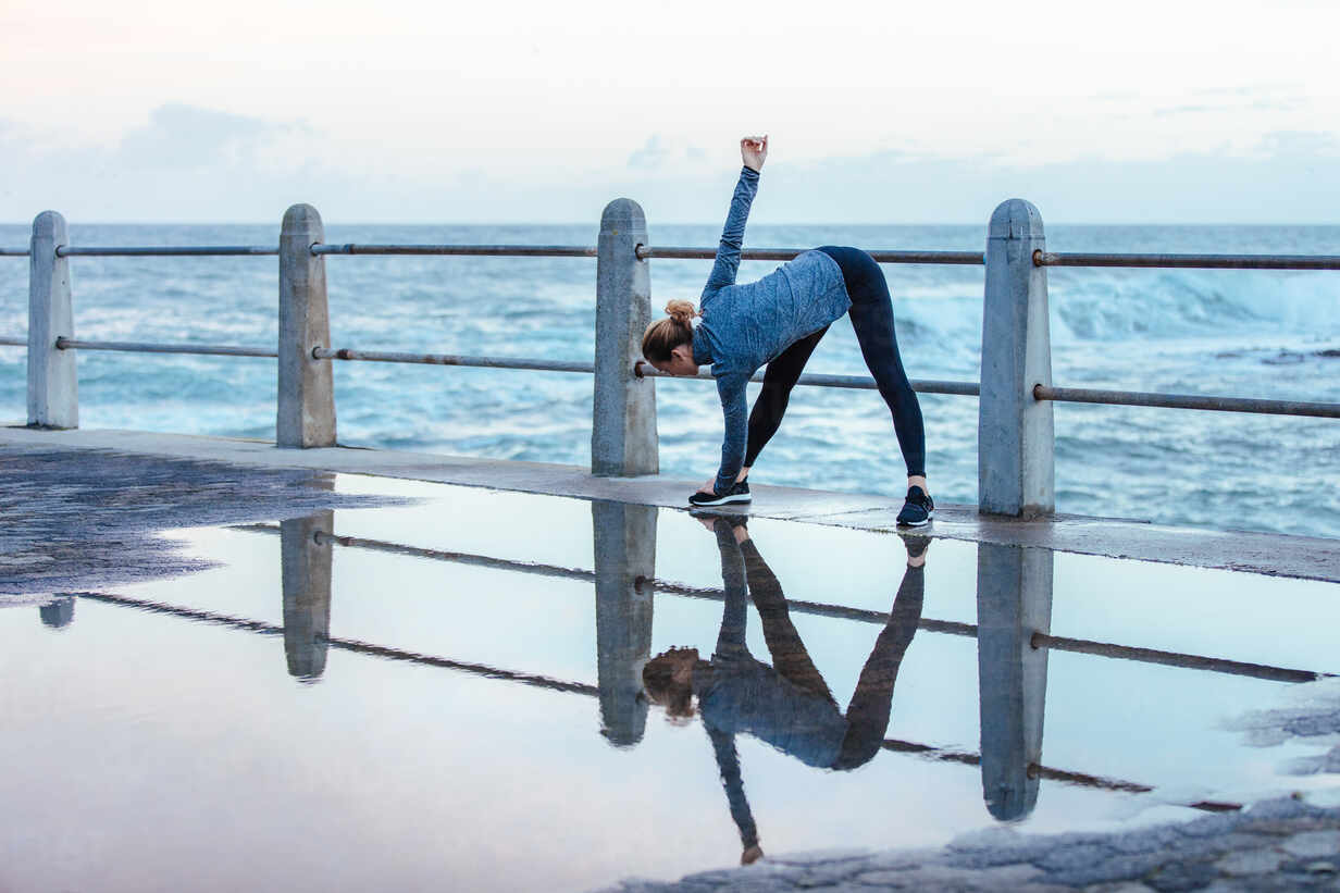 Young woman practicing yoga at beach – Jacob Lund Photography