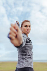 Woman exercising with a resistance band. Young fitness female training using a resistance band outdoors. - JLPSF01438