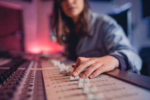 Woman hands mixing audio in recording studio. Female hands working on music mixer. Music production technology. - JLPSF01484