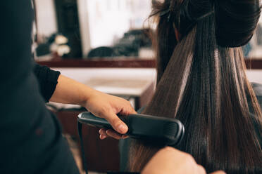 Friseur mit einem Haar begradigt, um das Haar zu glätten. Friseur arbeiten auf eine Frau die Frisur im Salon. - JLPSF01612