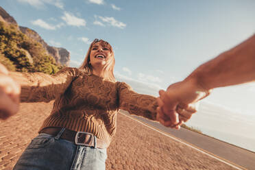 POV shot of smiling young woman spinning with her boyfriend along the road. Caucasian female holding hands of her boyfriend and laughing. - JLPSF01686