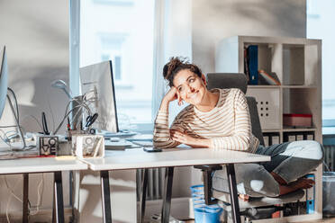 Thoughtful businesswoman day dreaming and leaning on desk in office - JOSEF13531