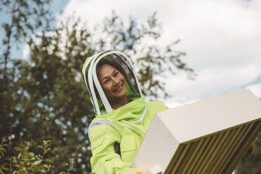 Glücklicher Imker hält Bienenstockbehälter - IEF00157
