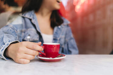 Frau hält Espressotasse auf dem Tisch in einem Cafe - ASGF02900