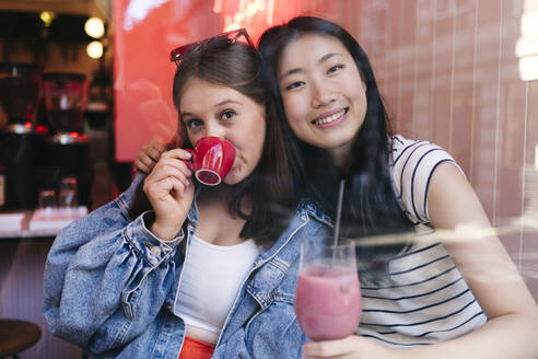 Junges lesbisches Paar genießt Getränke in einem Cafe - ASGF02906