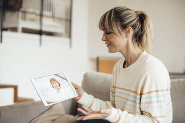 Frau bei Online-Konsultation mit Arzt über Tablet-PC zu Hause - JOSEF13598