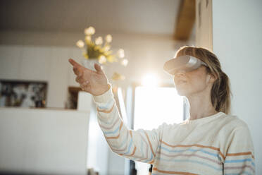 Frau hat Spaß beim Tragen eines Virtual-Reality-Headsets zu Hause - JOSEF13647