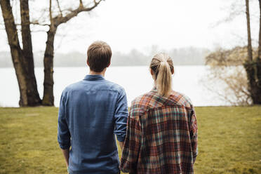 Man and woman looking at lake - JOSEF13686