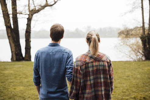 Man and woman looking at lake - JOSEF13686