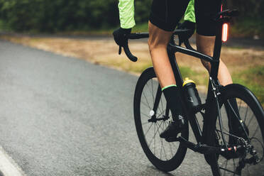 Ein Sportler trainiert hart für ein Radrennen auf einer Landstraße. Ein Radrennfahrer fährt auf einer Straße auf dem Lande. - JLPSF01897