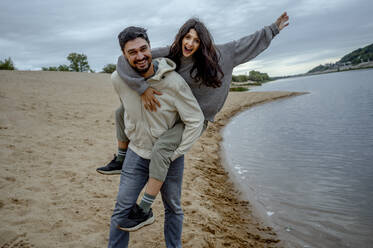 Happy couple having fun at riverbank on weekend - ANAF00072