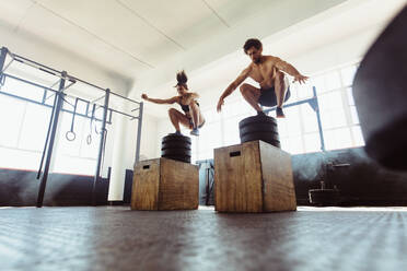 Gesunder Mann und Frau beim Boxen im Fitnessstudio, fitte junge Leute beim Cross-Training im Fitnessstudio. - JLPSF02024